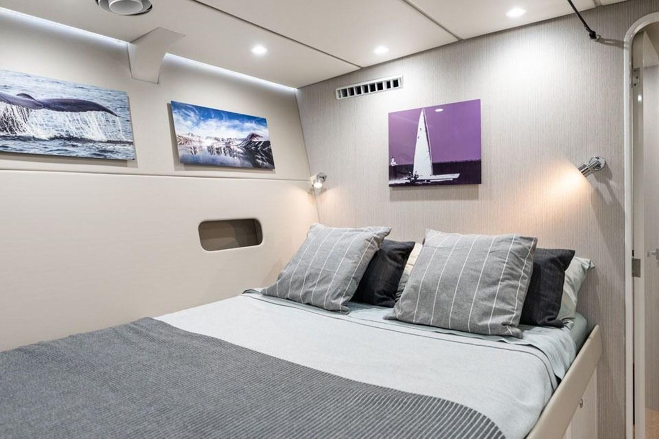 a bed with a blue blanket aboard COCHISE Yacht for Sale