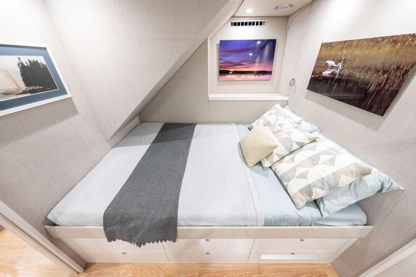 a bed with a black and white striped pillow aboard COCHISE Yacht for Sale