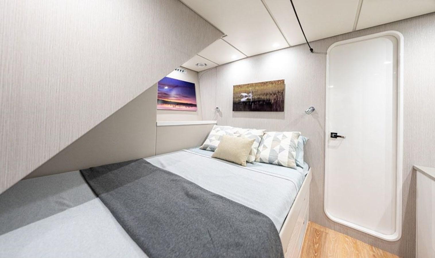 a bedroom with a bed and a television on the wall aboard COCHISE Yacht for Sale