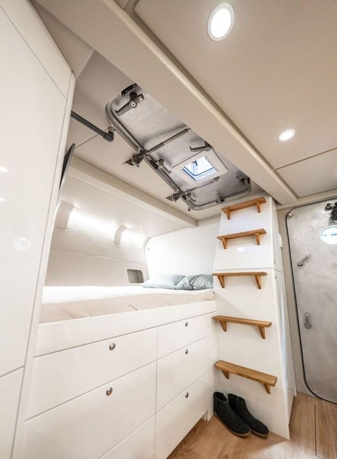 a white room with a white bed and a wooden slat aboard COCHISE Yacht for Sale