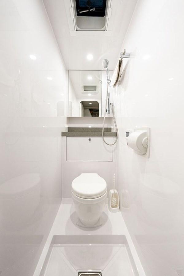 a white bathroom with a toilet aboard COCHISE Yacht for Sale