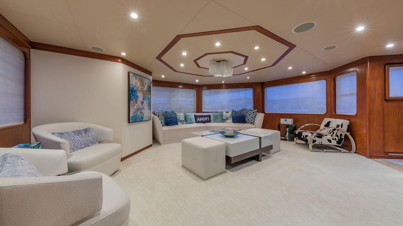 a living room with a large white couch and a large window aboard AT LAST Yacht for Charter