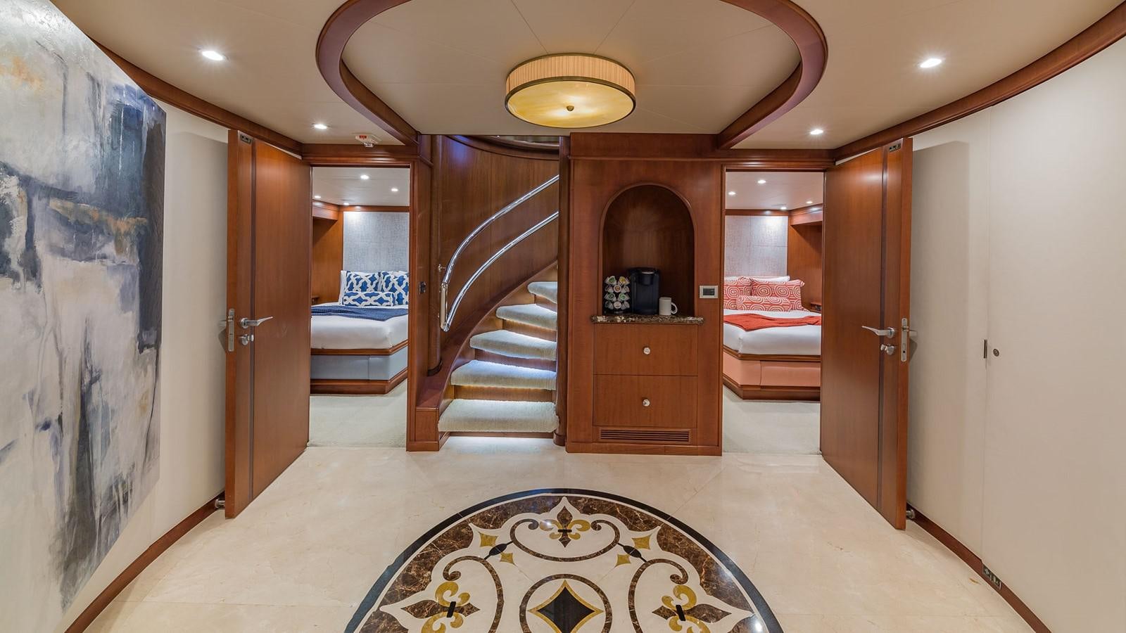 a large room with a set of stairs and a rug aboard AT LAST Yacht for Charter