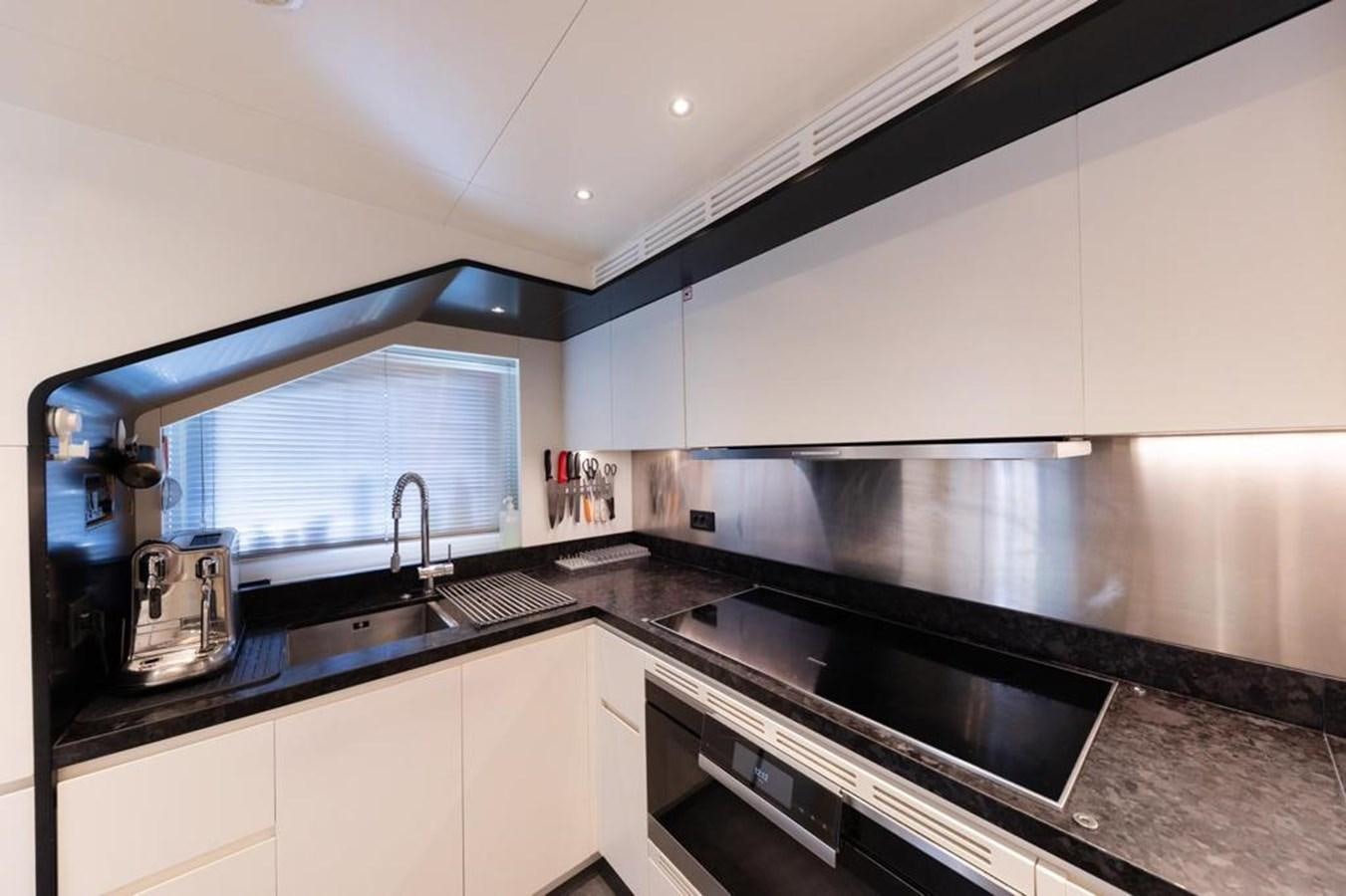 a kitchen with black counter tops aboard QUEEN J II Yacht for Sale