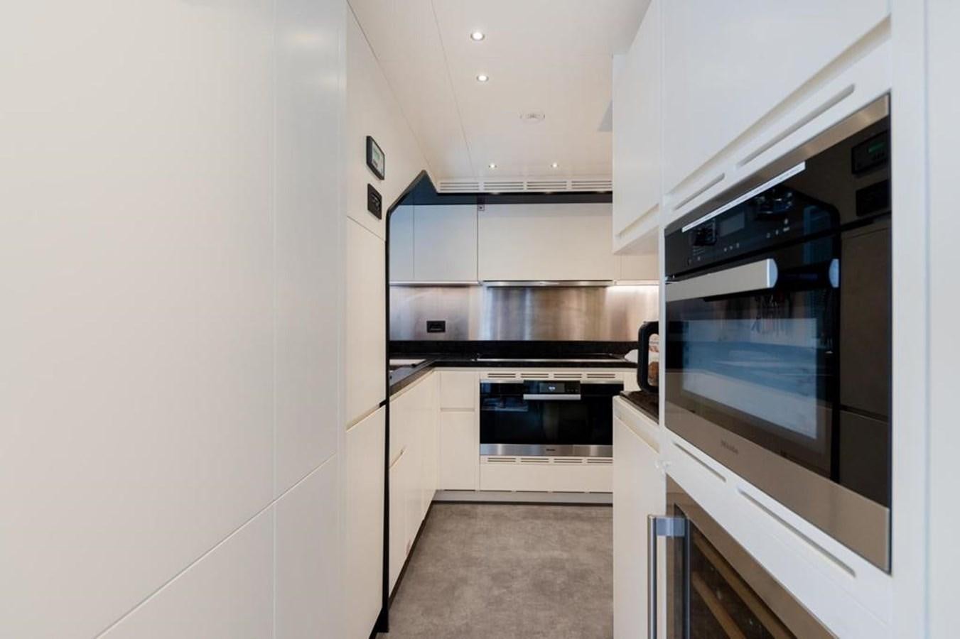 a kitchen with white cabinets aboard QUEEN J II Yacht for Sale