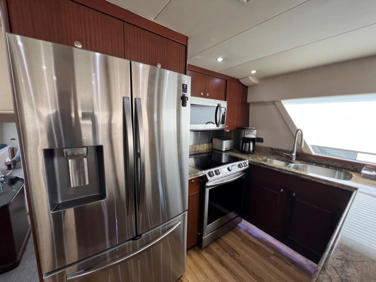 a kitchen with a stainless steel refrigerator aboard LUCKY AGAIN Yacht for Sale