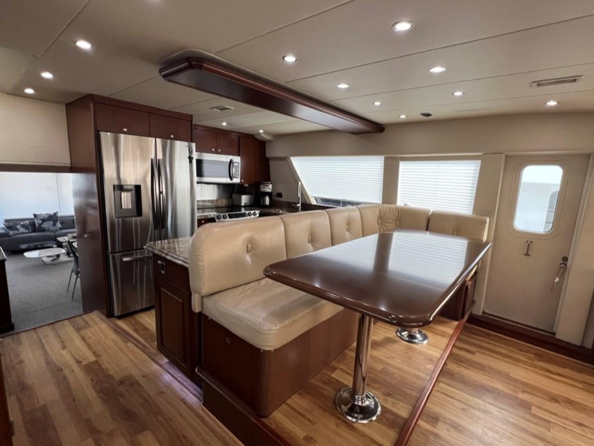 a living room with a bar and a table aboard LUCKY AGAIN Yacht for Sale