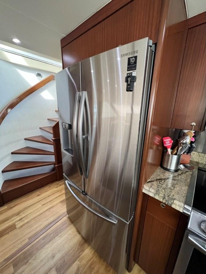 a stainless steel refrigerator in a kitchen aboard LUCKY AGAIN Yacht for Sale