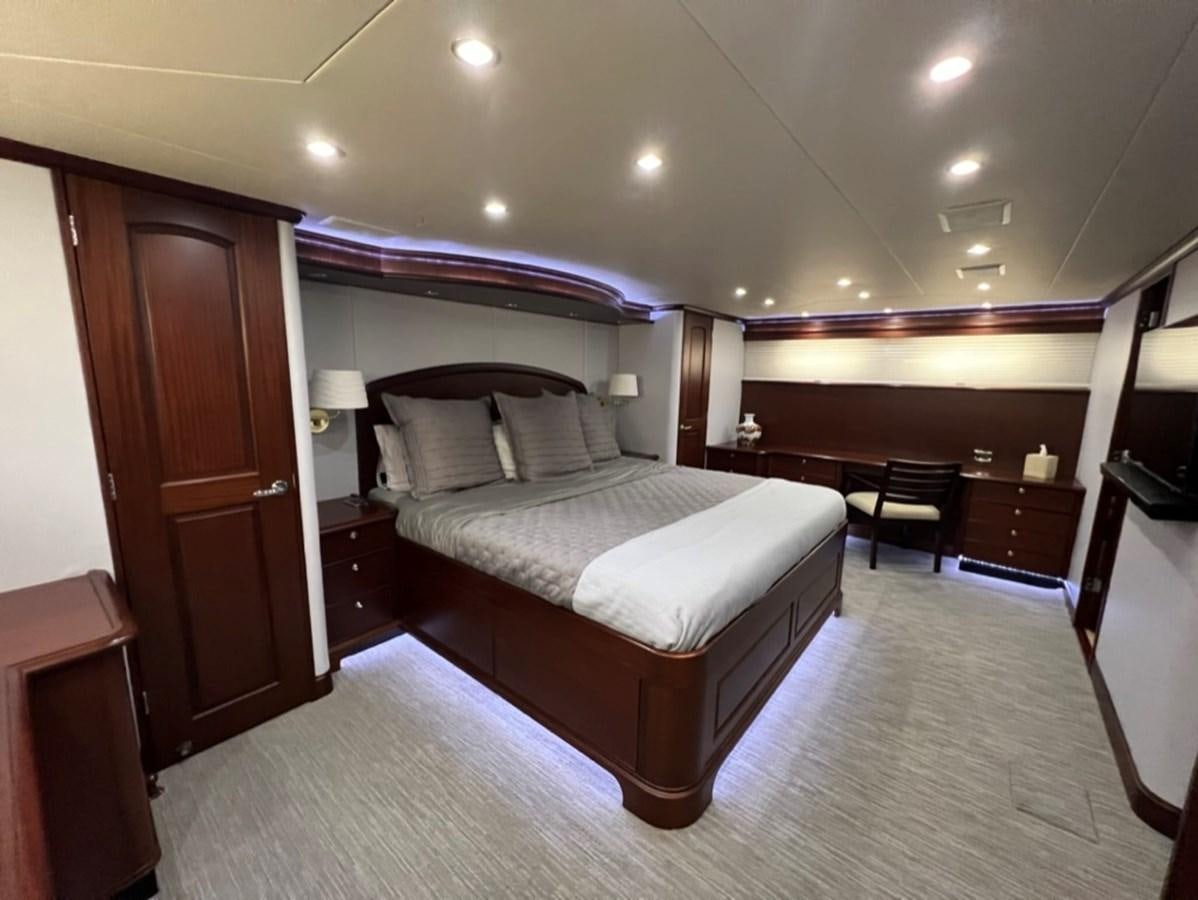 a hotel room with a bed and desk aboard LUCKY AGAIN Yacht for Sale