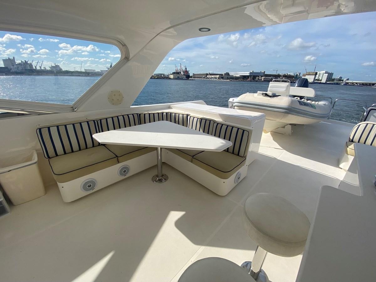 a group of white pianos on a table in front of a large window aboard LUCKY AGAIN Yacht for Sale