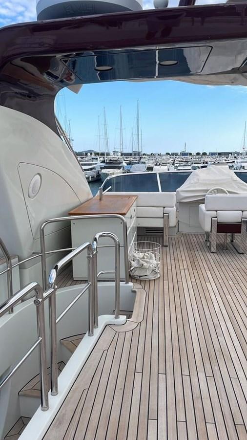 a deck with chairs and a table on it aboard DUKE Yacht for Sale
