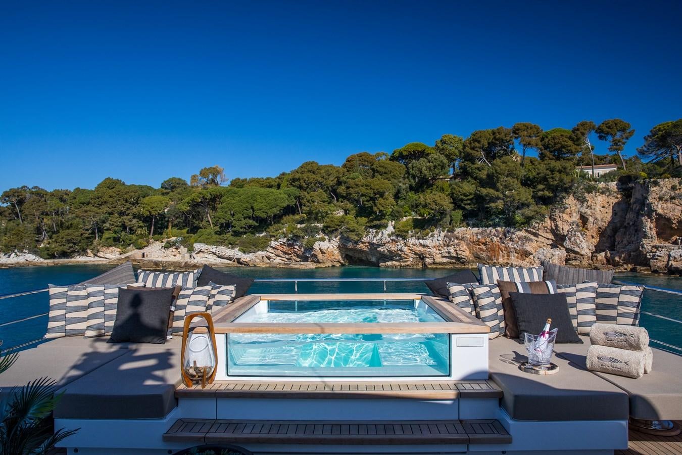 a large swimming pool with a large rock wall behind it aboard SABAI Yacht for Sale