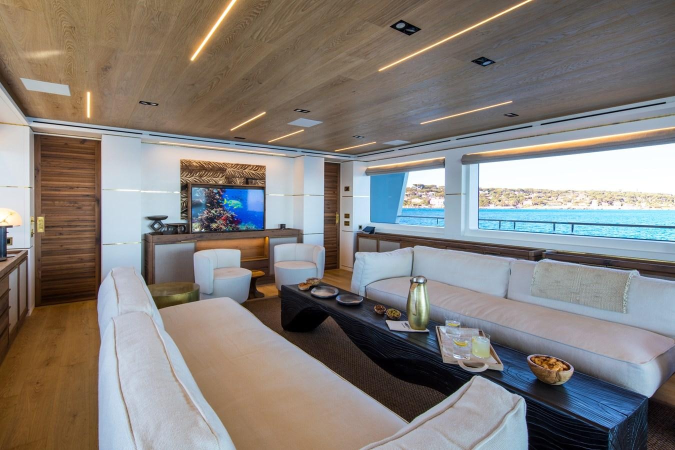 a room with a couch and a table and a tv aboard SABAI Yacht for Sale