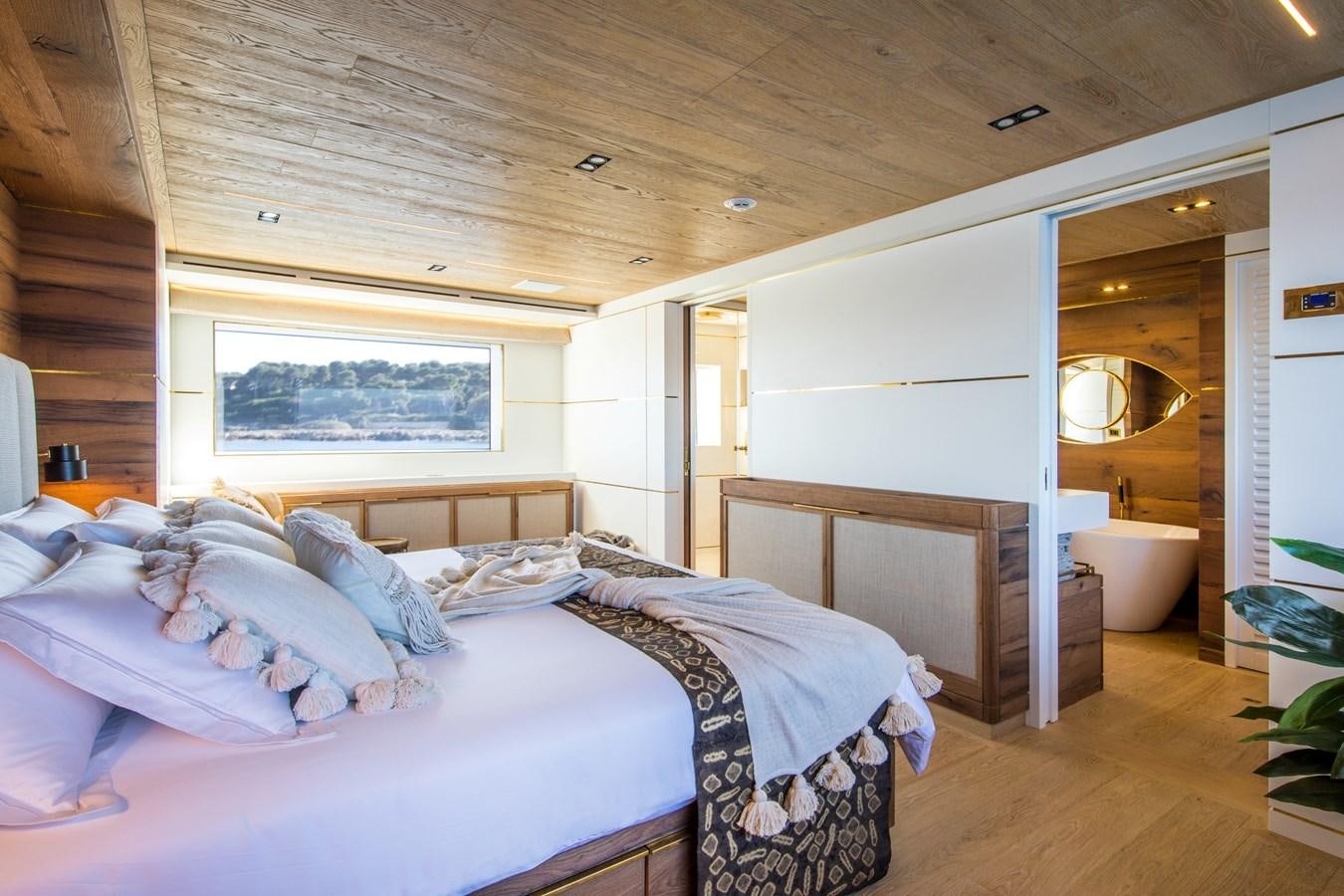 a bedroom with a bed and a mirror aboard SABAI Yacht for Sale