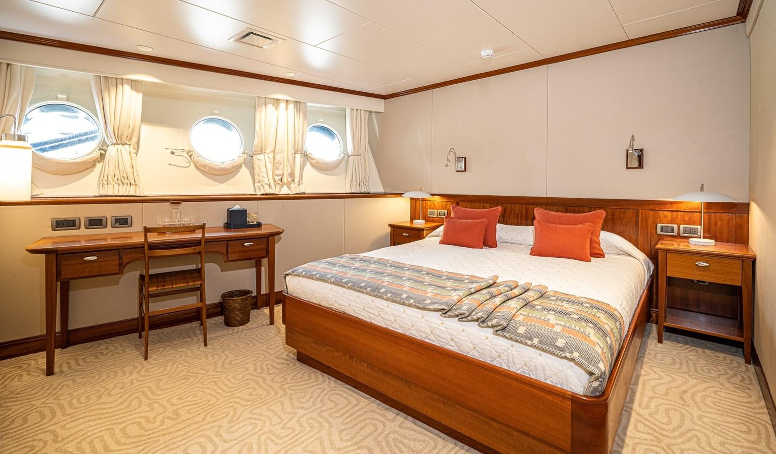 a bedroom with a bed and desk aboard ASTERIA Yacht for Charter