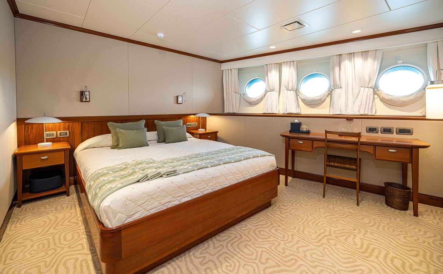 a bedroom with a bed and desk aboard ASTERIA Yacht for Sale