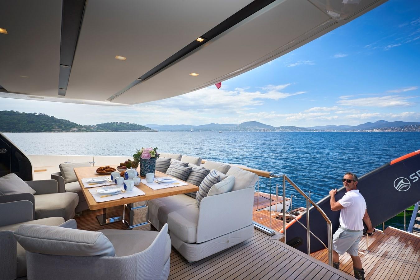 a person standing on a deck overlooking a large body of water aboard OCEAN 6 Yacht for Sale