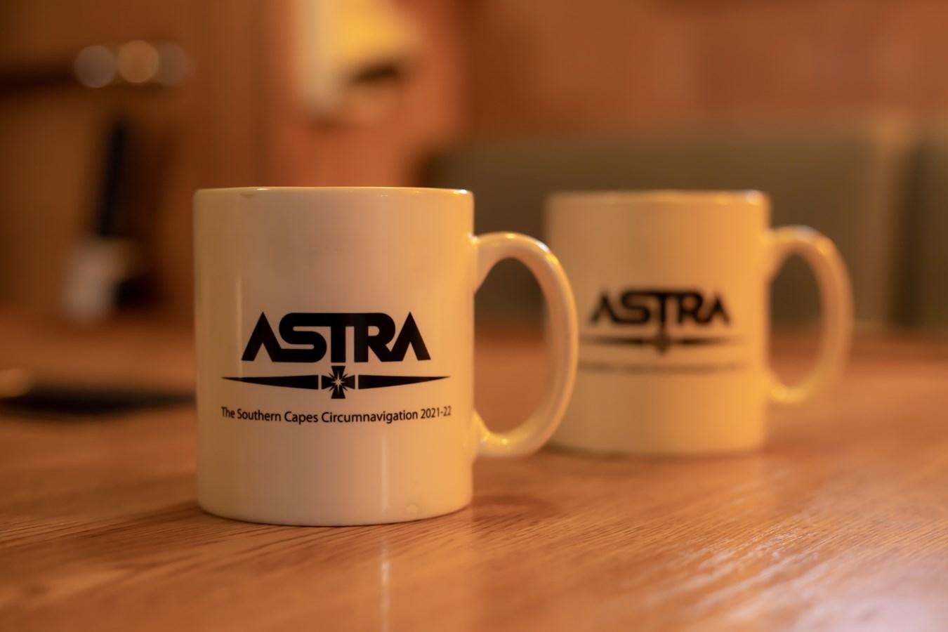 a pair of white mugs on a wooden surface aboard ASTRA Yacht for Sale