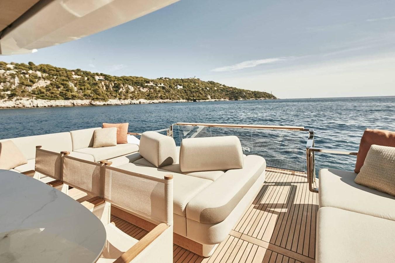 a deck with chairs and a body of water in the background aboard ROCKSTAR Yacht for Sale