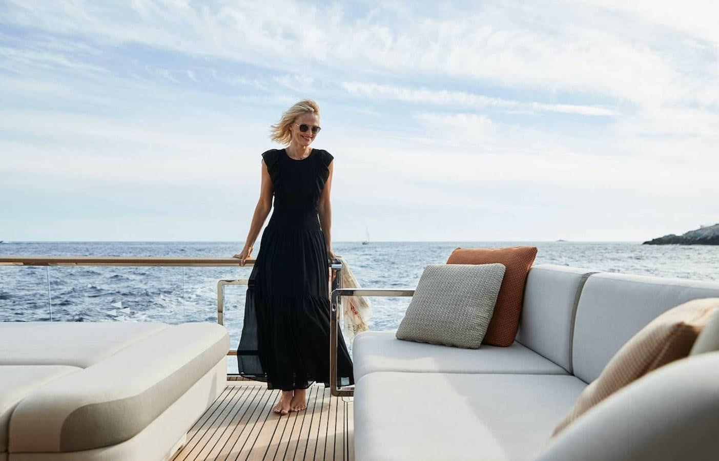 a person standing on a deck overlooking a beach aboard ROCKSTAR Yacht for Sale