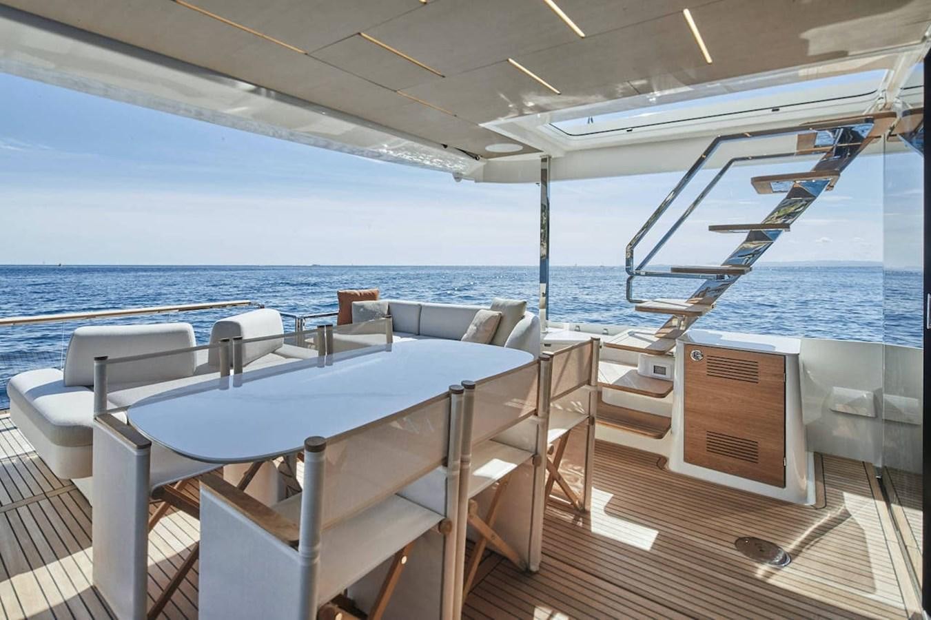 a table and chairs on a deck overlooking a body of water aboard ROCKSTAR Yacht for Sale