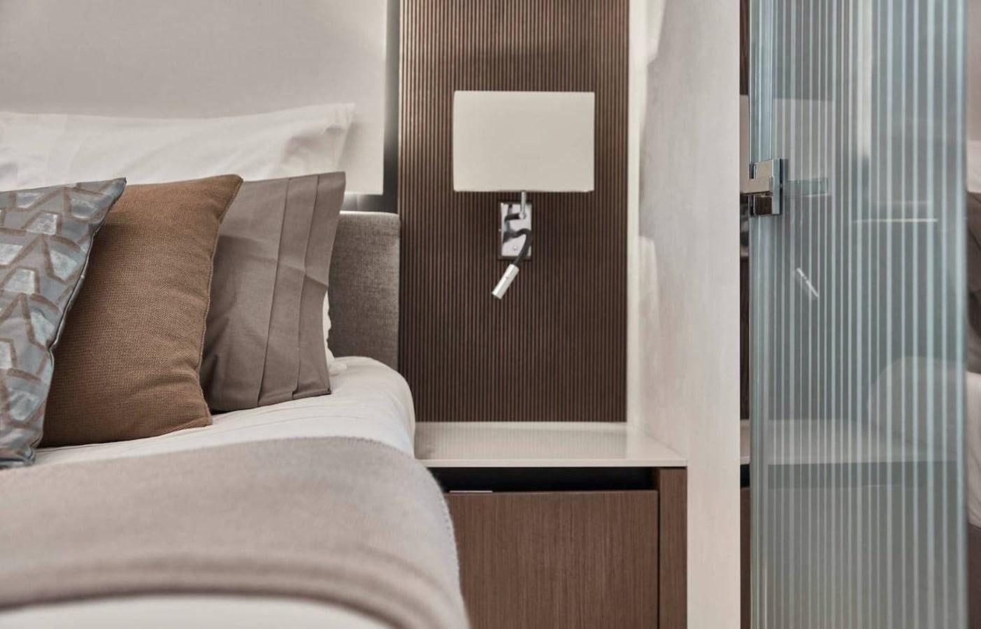 a room with a bed and a lamp aboard ROCKSTAR Yacht for Sale