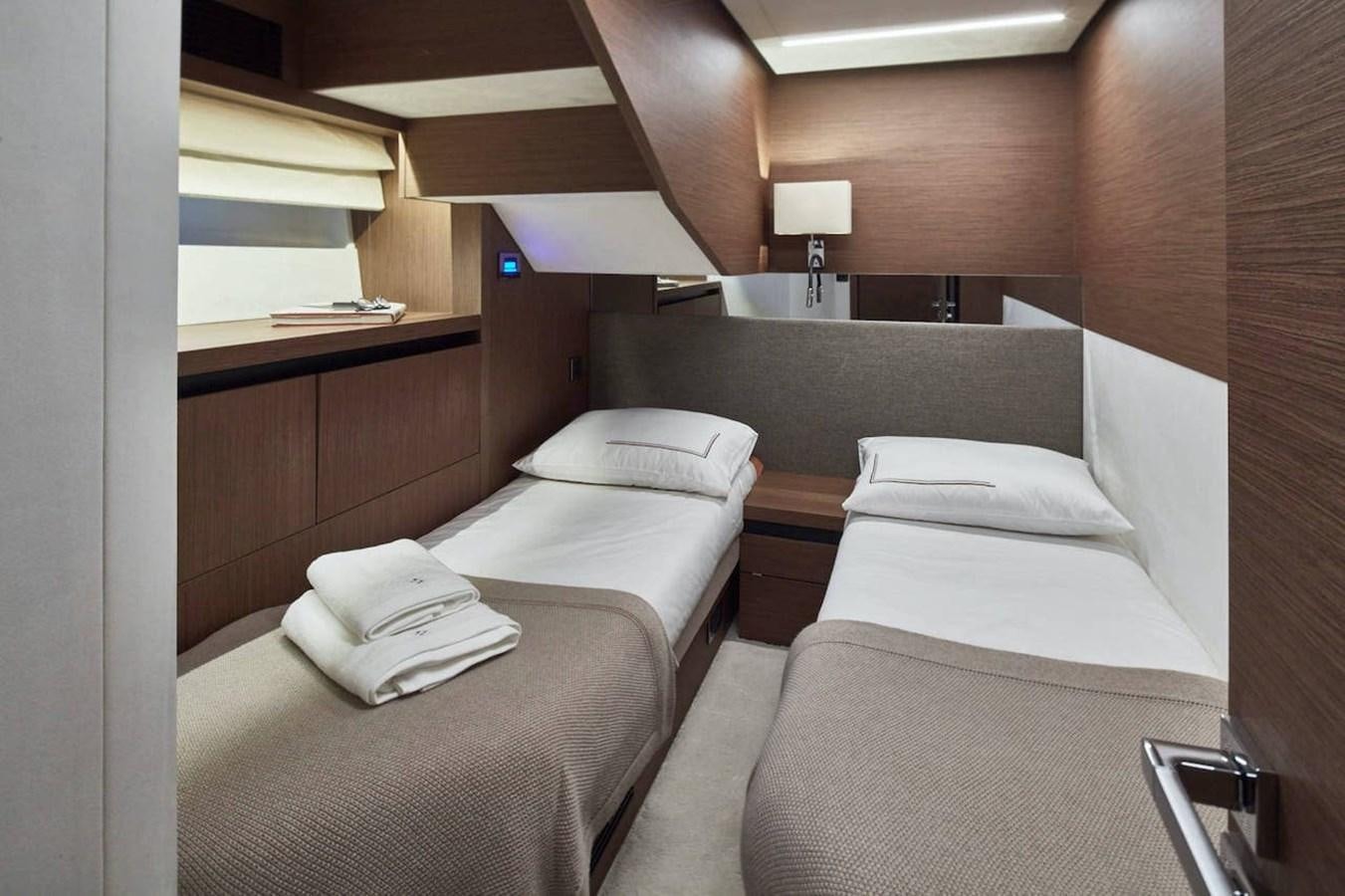 a room with beds and a lamp aboard ROCKSTAR Yacht for Sale