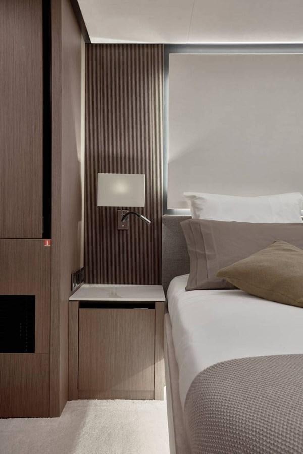 a room with a bed and a lamp aboard ROCKSTAR Yacht for Sale