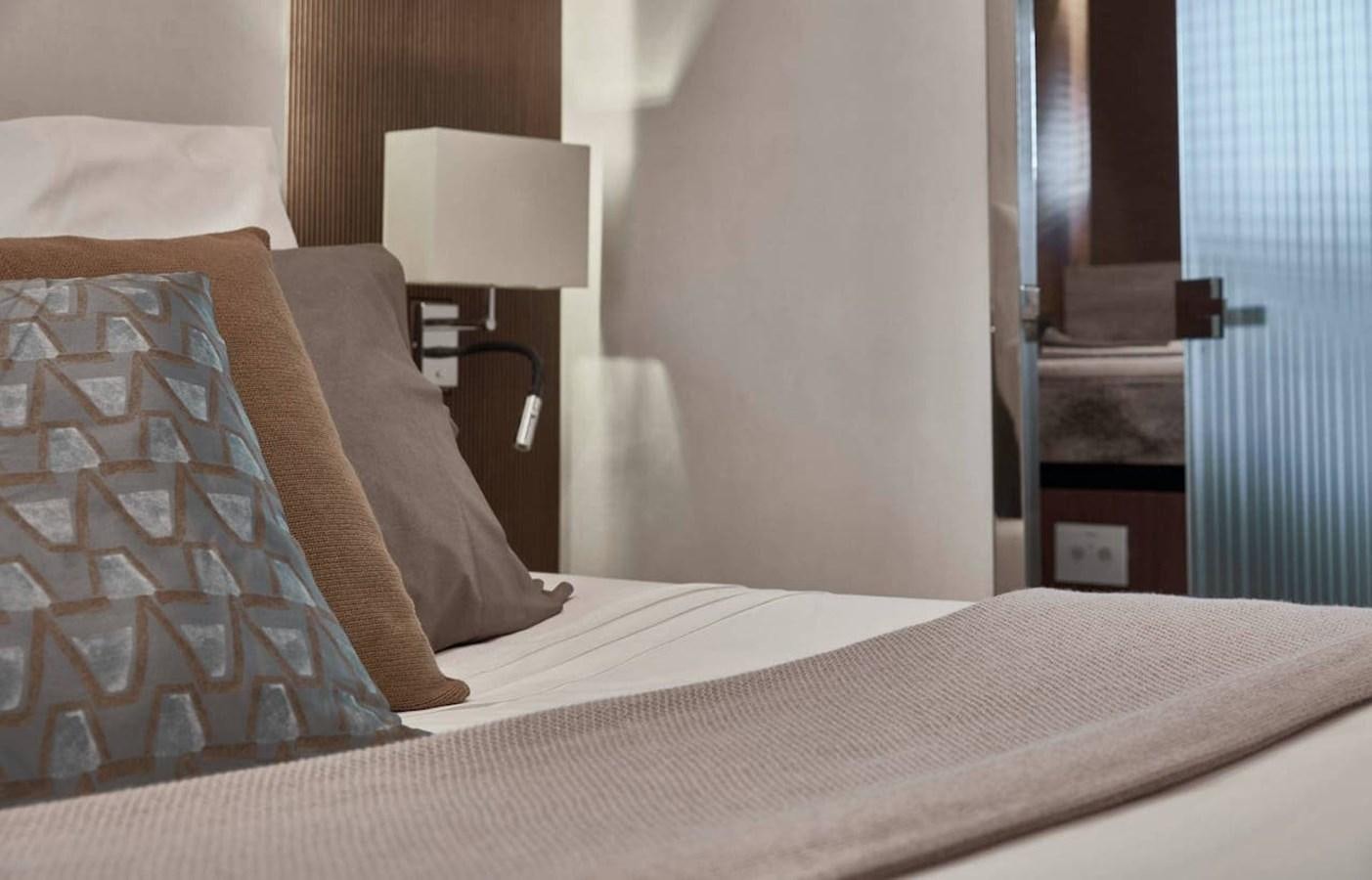 a bed with a lamp on it aboard ROCKSTAR Yacht for Sale