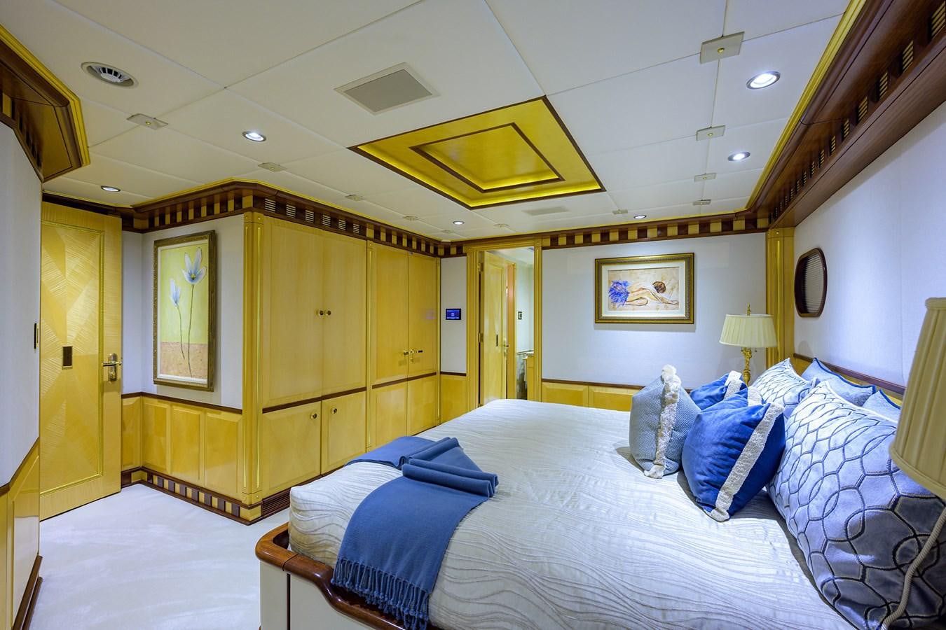 a bedroom with a bed and a wood closet aboard STARSHIP Yacht for Charter