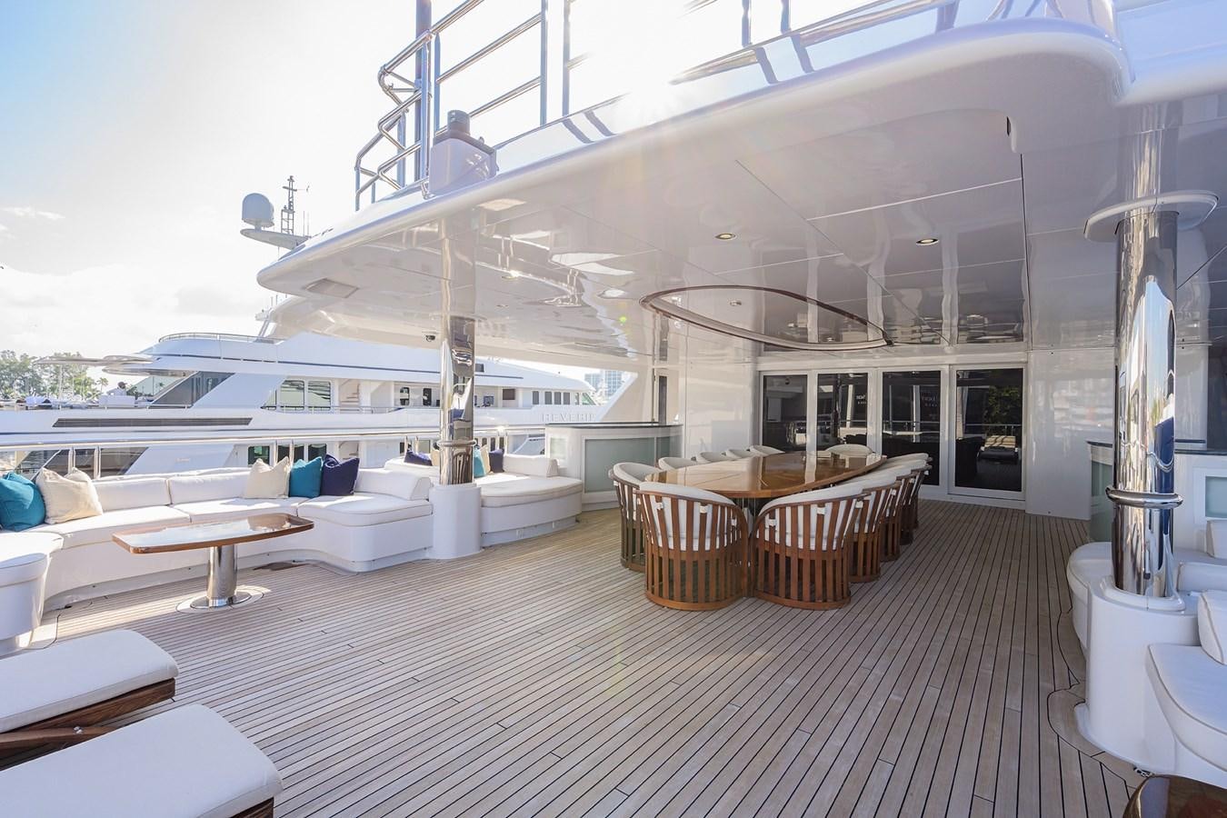a large white lounge area with tables and chairs aboard STARSHIP Yacht for Charter