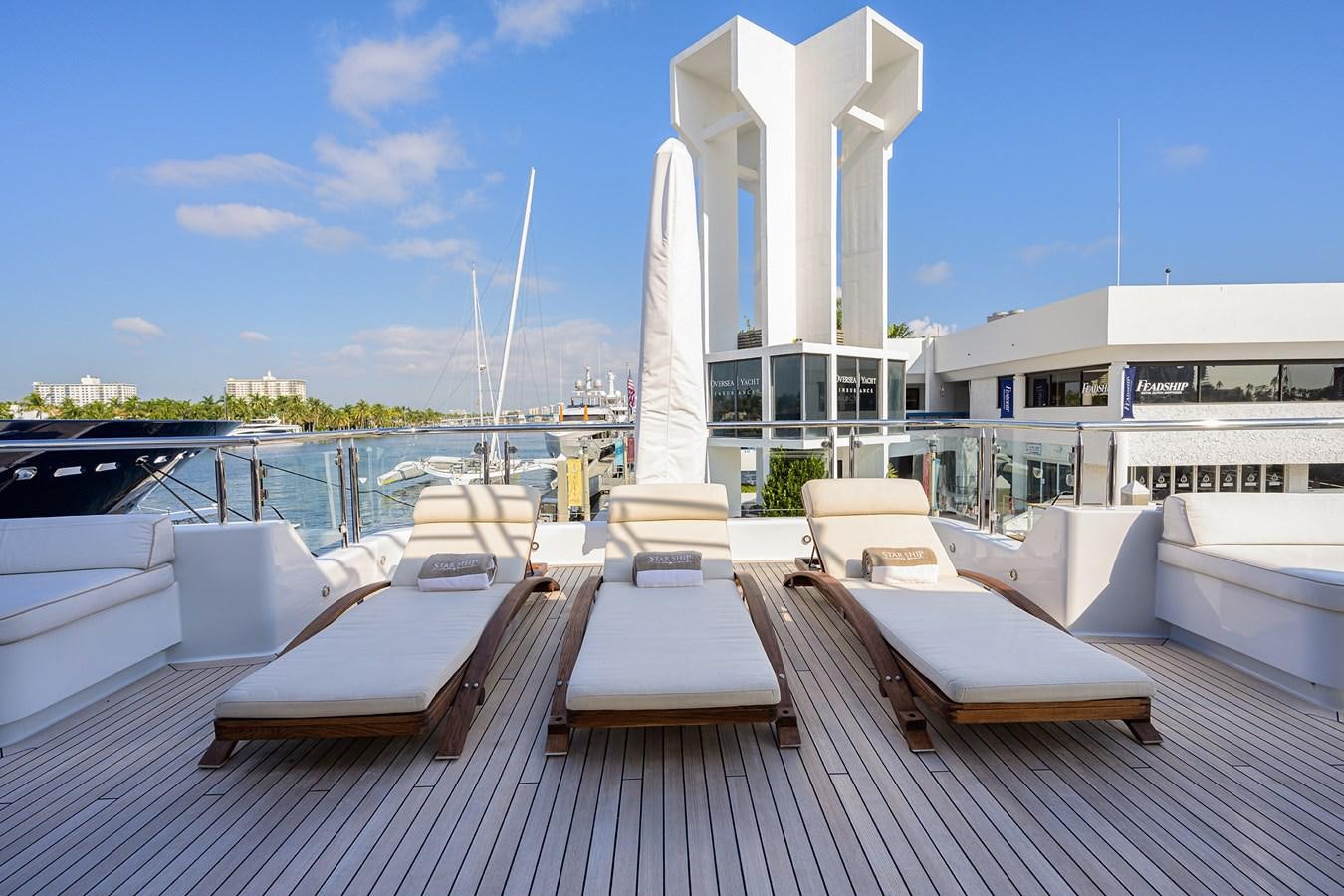 a group of lounge chairs on a deck with a fountain in the middle aboard STARSHIP Yacht for Charter