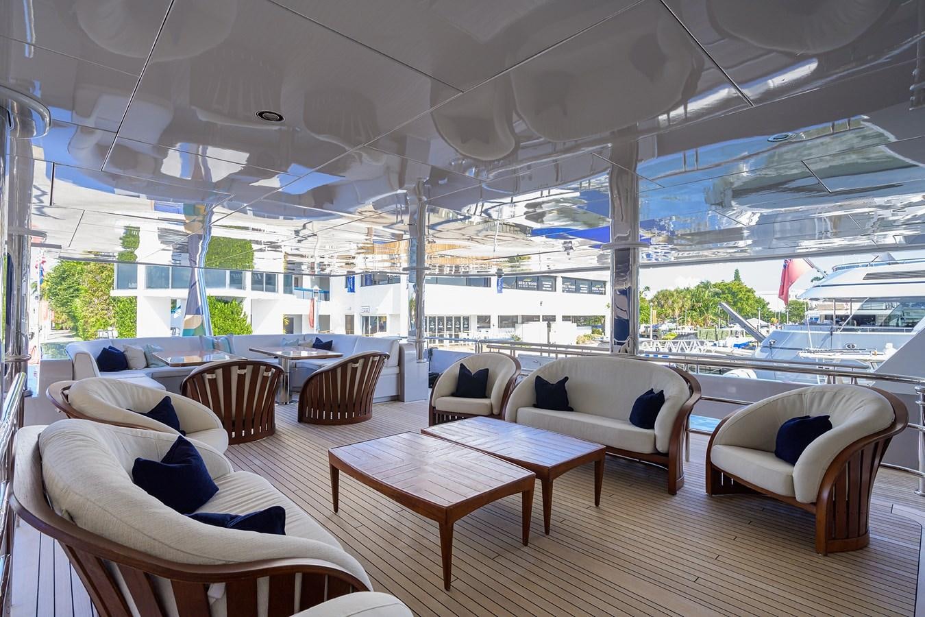 a room with a table chairs and a view of the water aboard STARSHIP Yacht for Charter