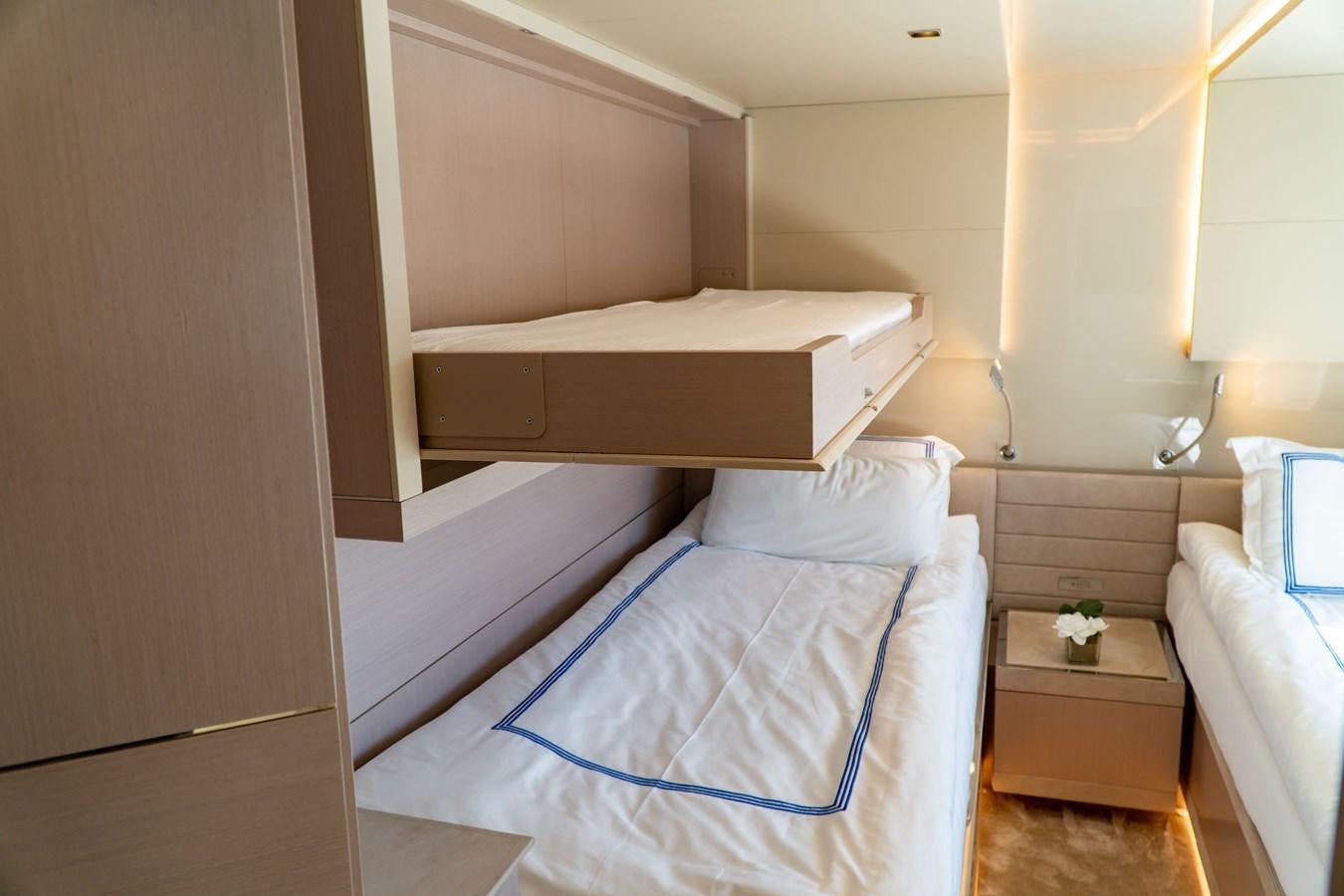 a room with a bed and a shelf with a white pillow aboard ARES Yacht for Sale
