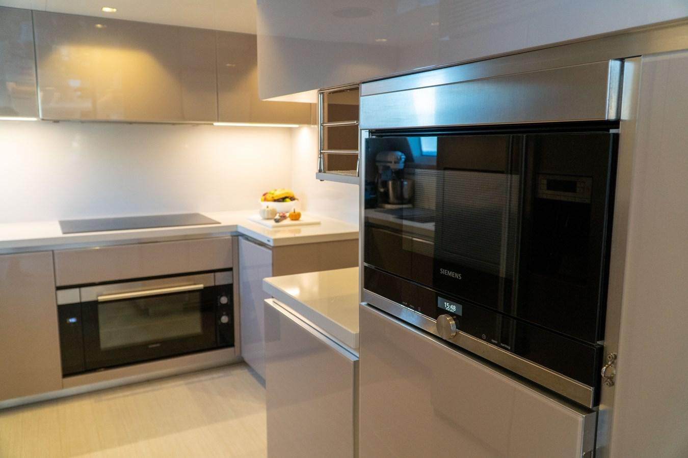 a kitchen with black appliances aboard ARES Yacht for Sale