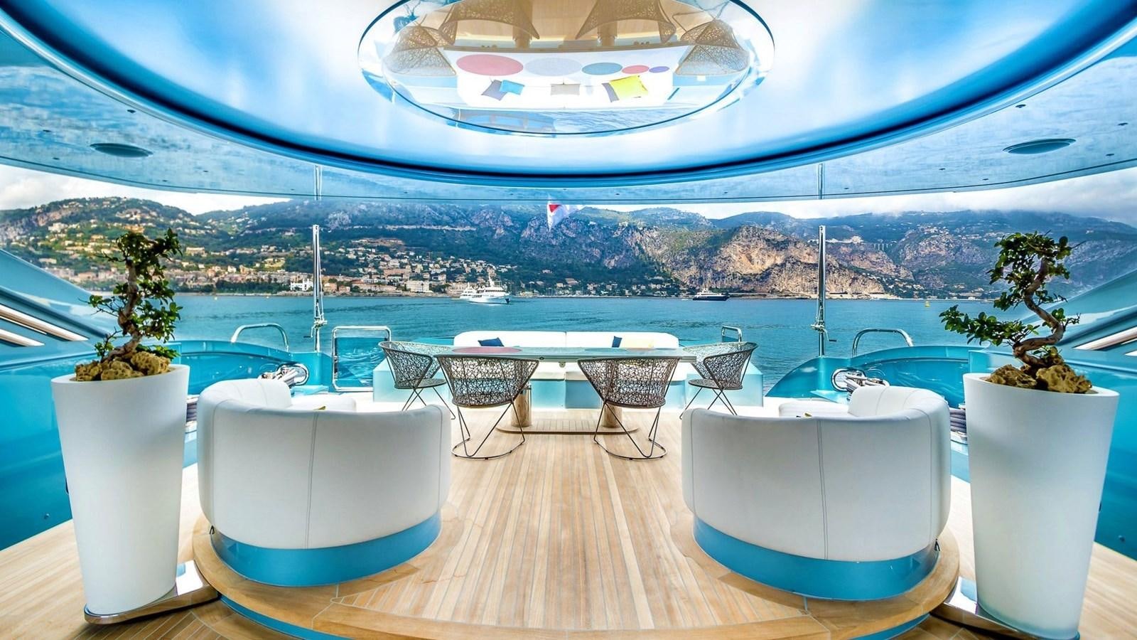 a table with chairs and a pool aboard QUEEN ALLA Yacht for Sale