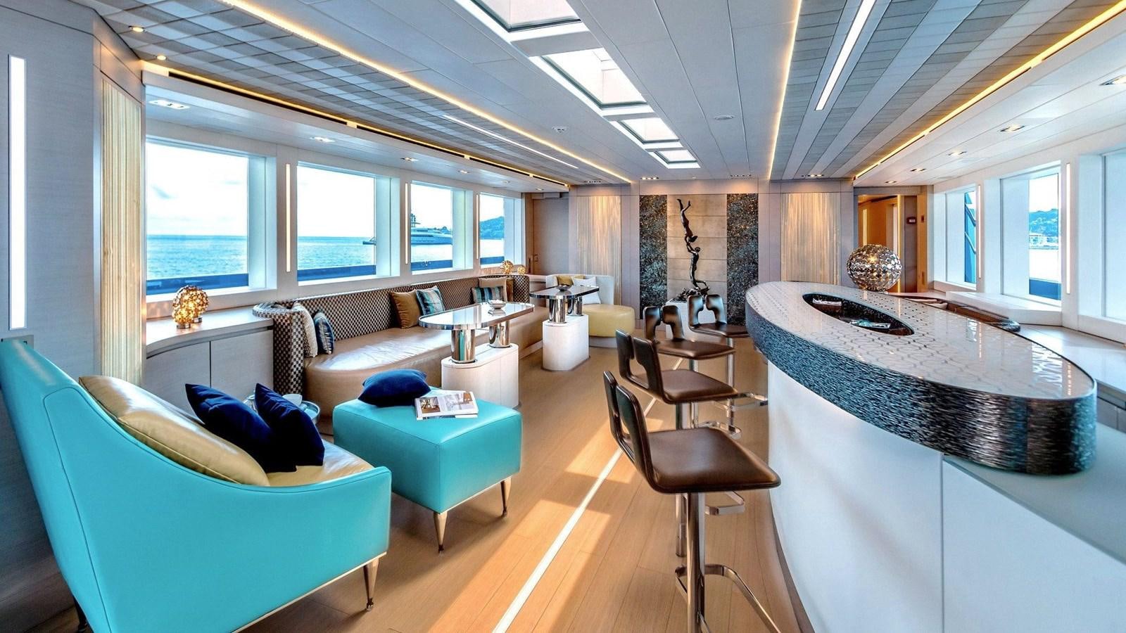 a living room with a large round table and a large window aboard QUEEN ALLA Yacht for Sale