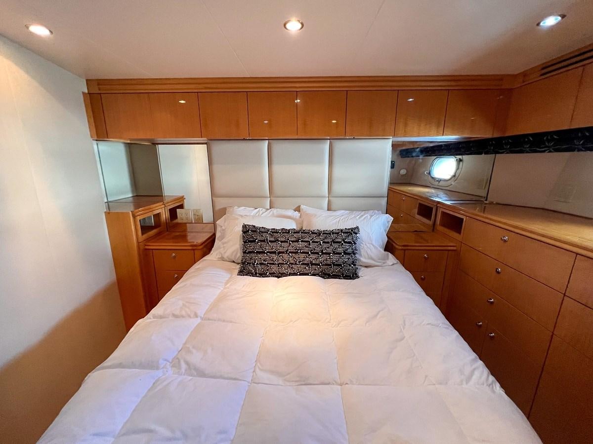 a bed with a white comforter aboard DESTINI IV Yacht for Sale