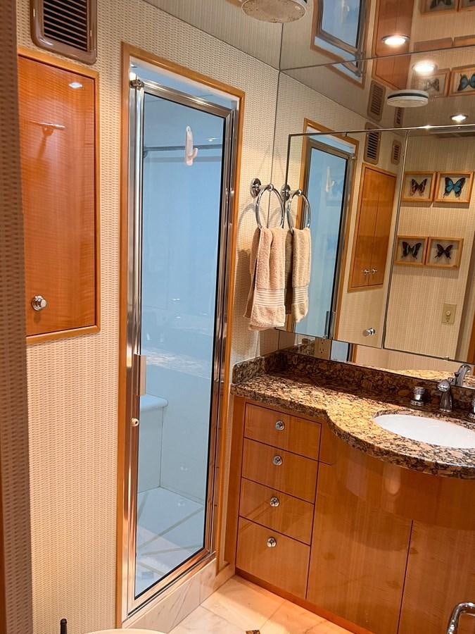 a bathroom with a glass shower door aboard DESTINI IV Yacht for Sale