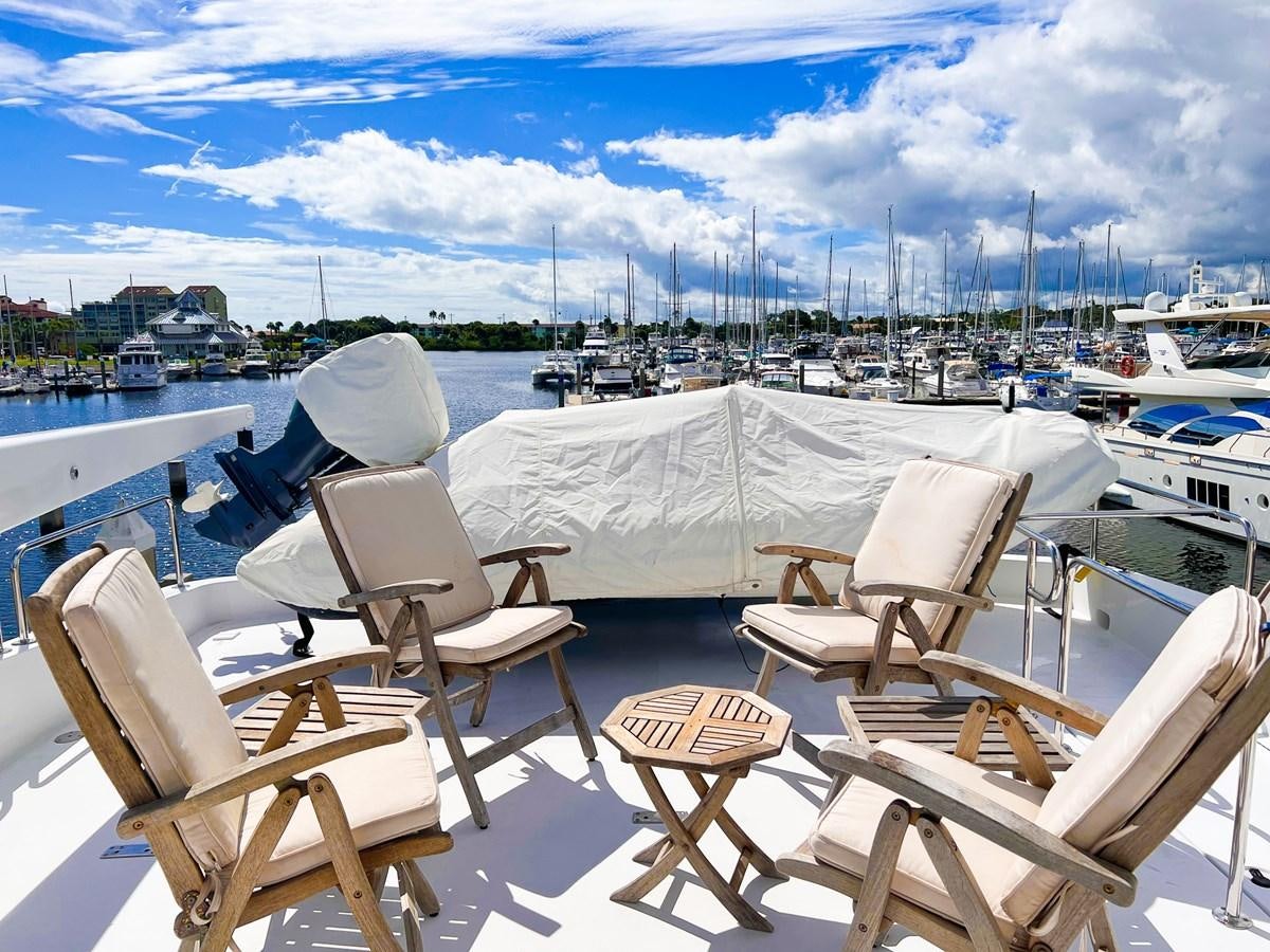 a group of chairs on a deck overlooking a marina aboard DESTINI IV Yacht for Sale