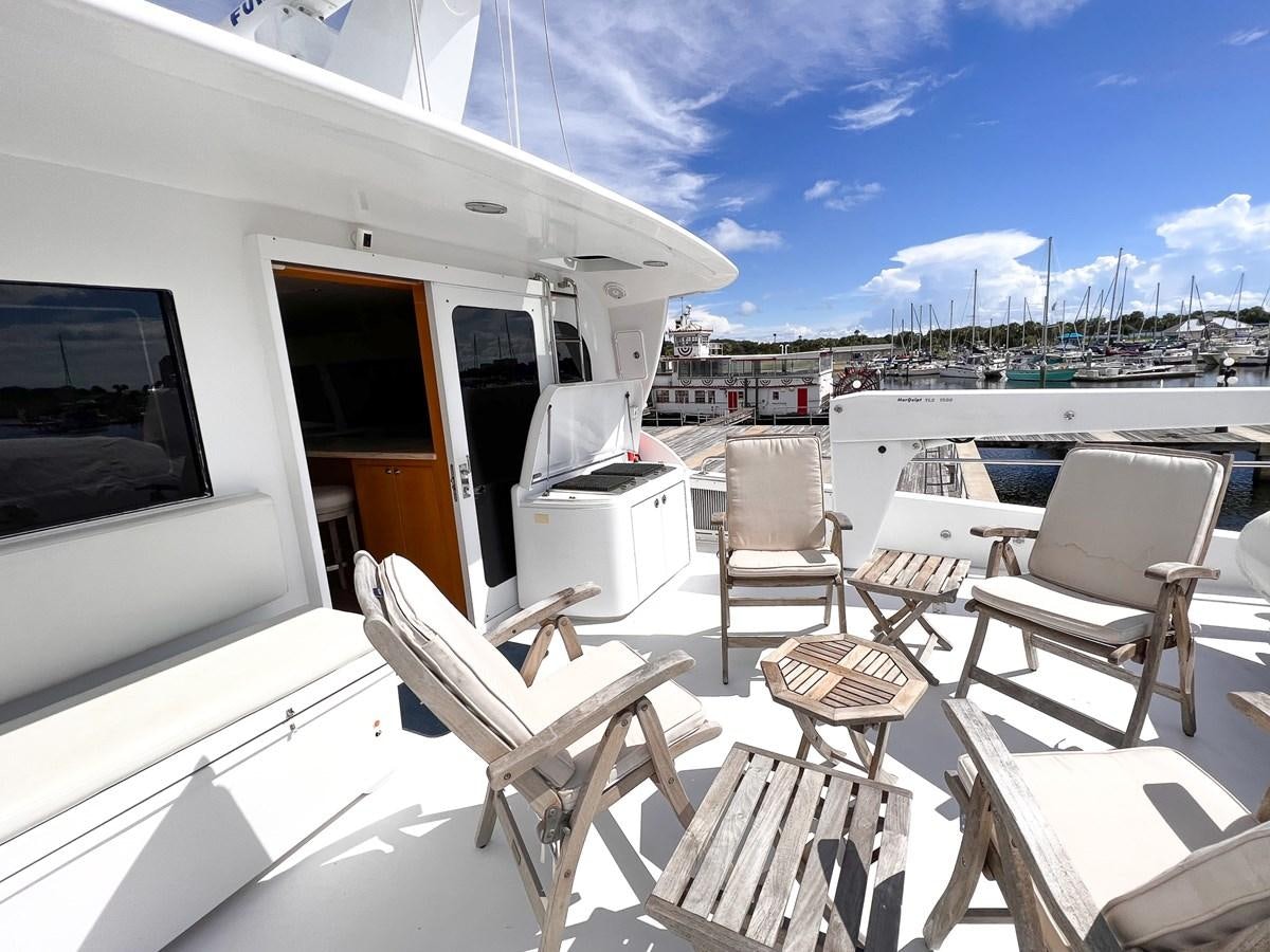 a deck with chairs and a table on it aboard DESTINI IV Yacht for Sale