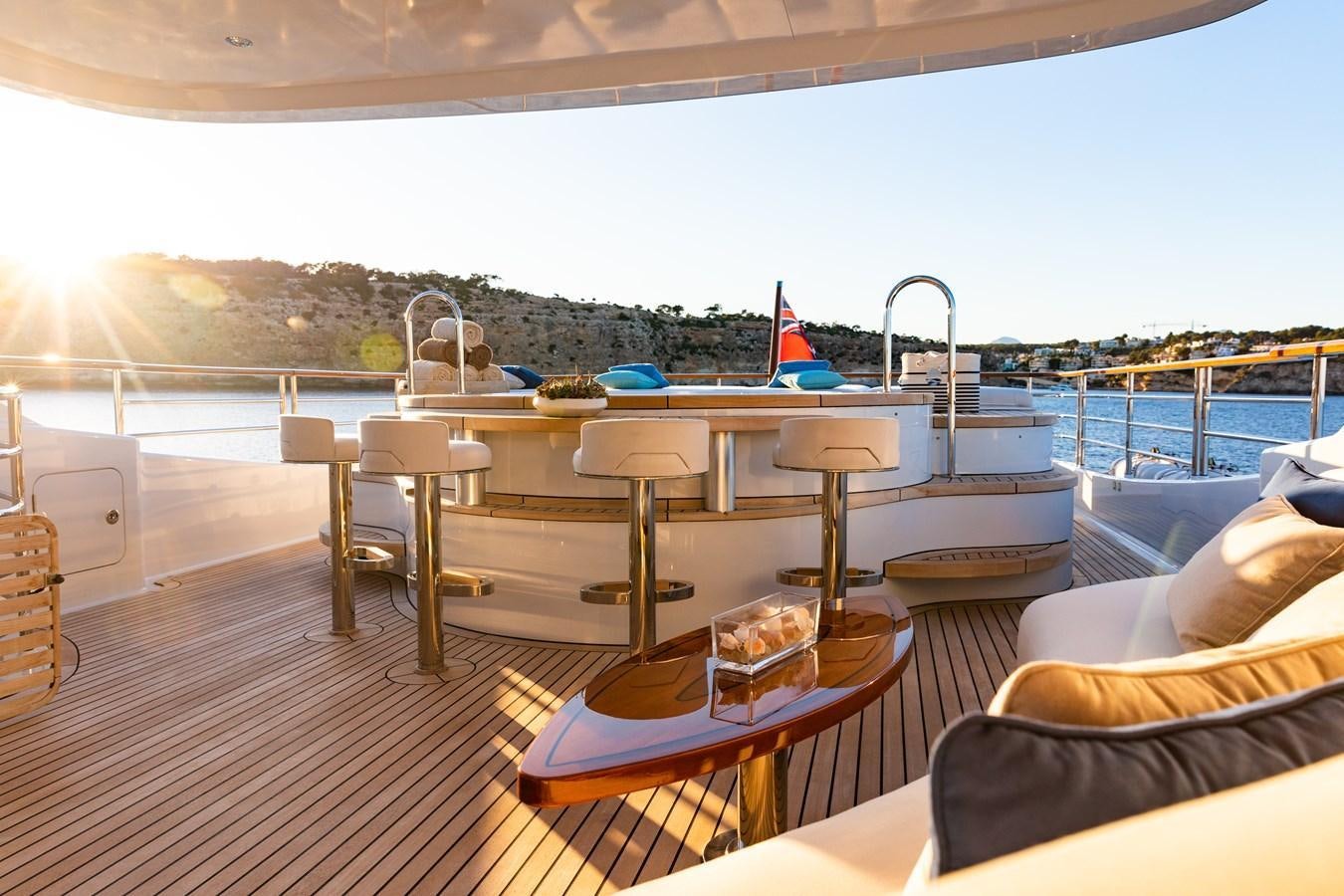 a deck with a table and chairs aboard SOLIS Yacht for Sale