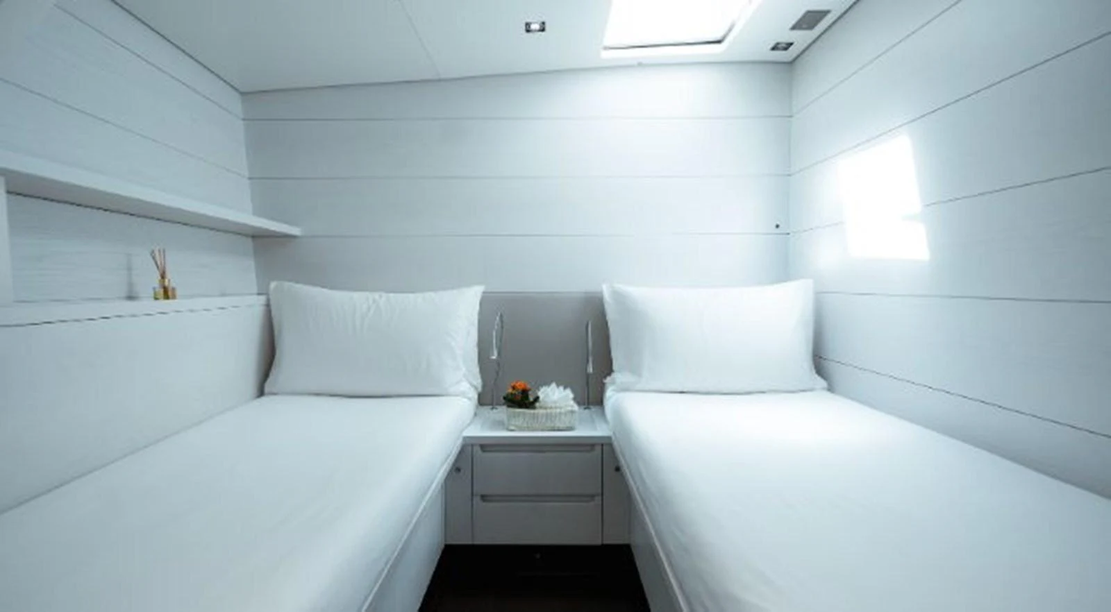 a room with white furniture aboard Y3K Yacht for Sale
