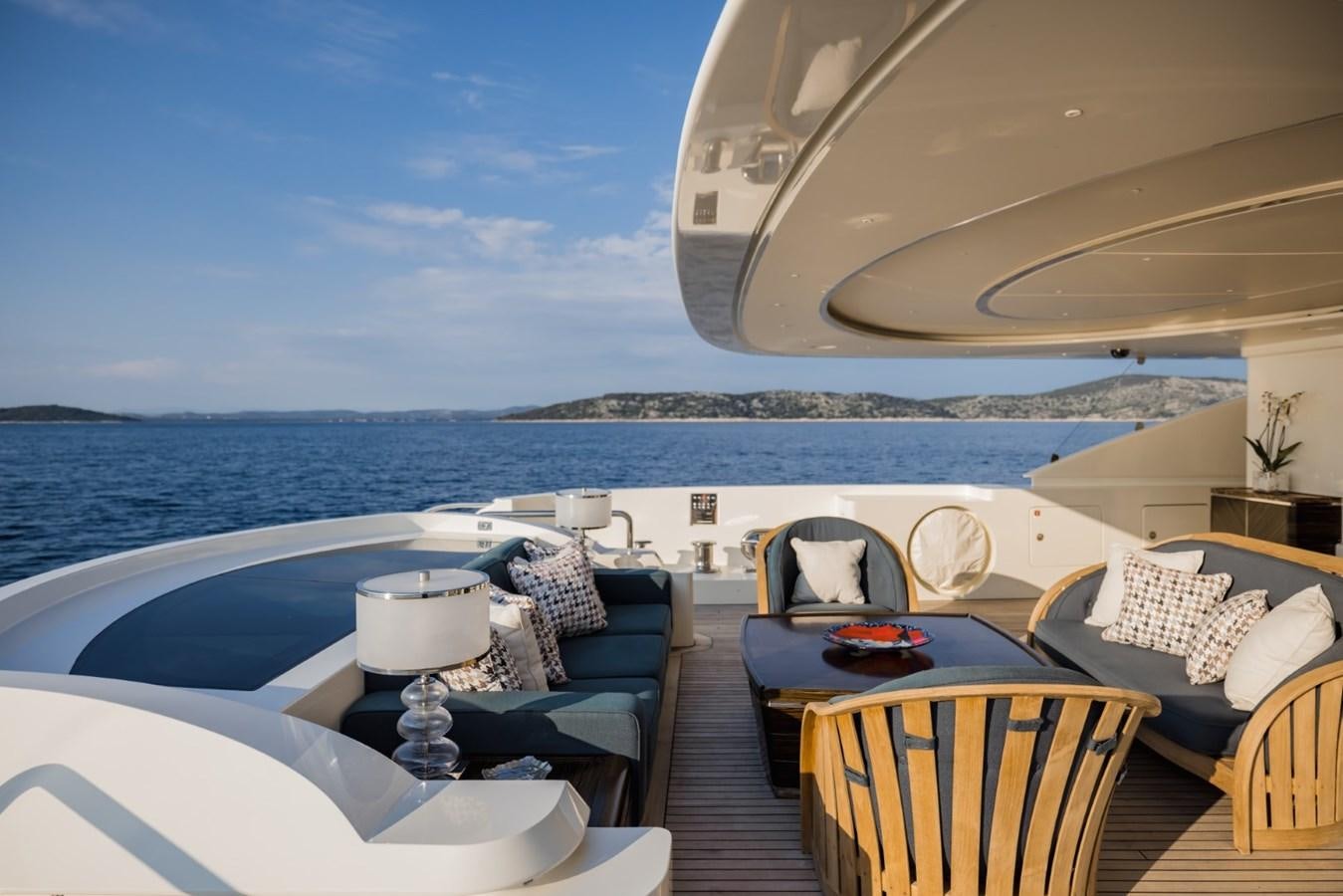 a room with a table and chairs on a deck overlooking a body of water aboard BELLE ANNA Yacht for Sale