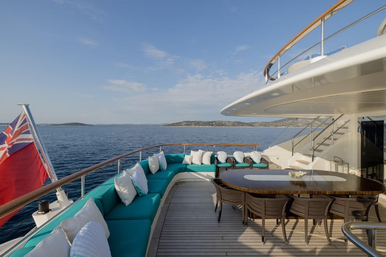 a deck with chairs and tables on it and a body of water in the background aboard BELLE ANNA Yacht for Sale