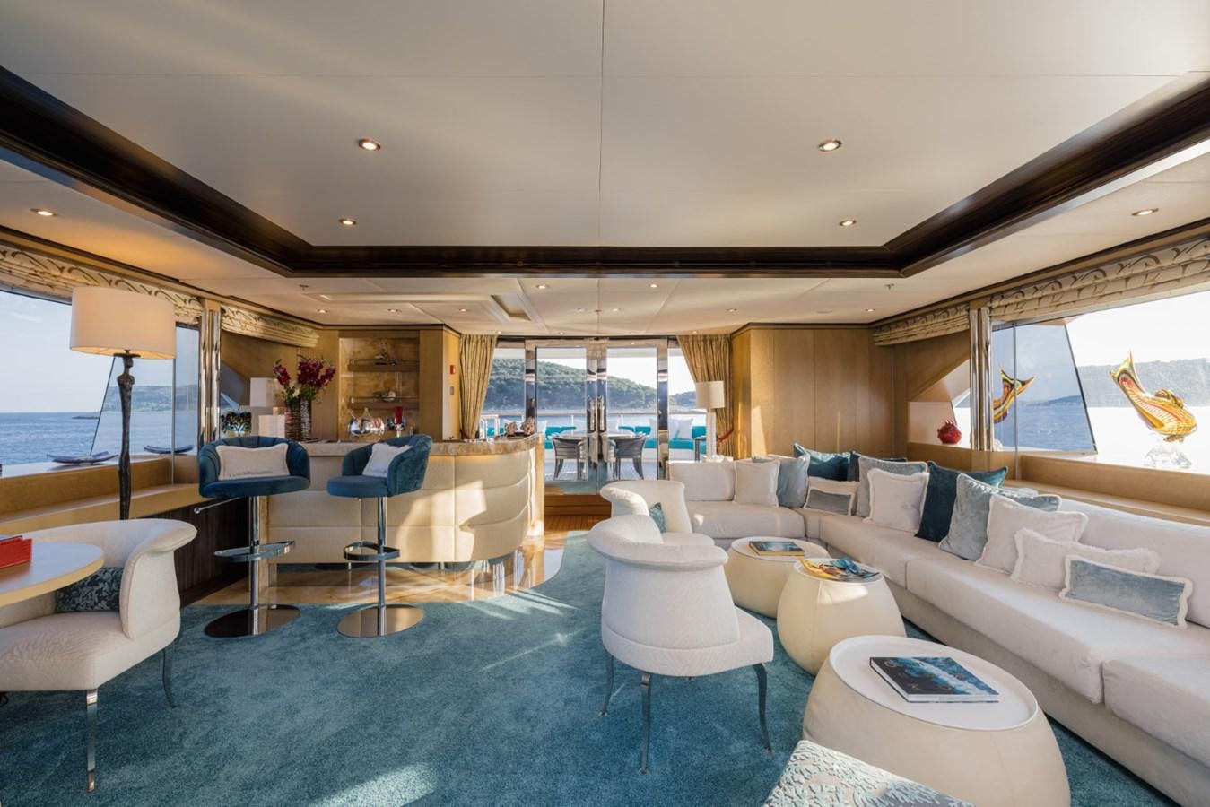a living room with a large blue rug and white furniture aboard BELLE ANNA Yacht for Sale