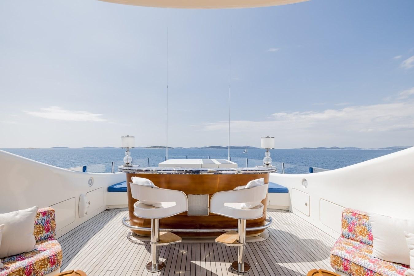 a table and chairs on a deck overlooking a body of water aboard BELLE ANNA Yacht for Sale
