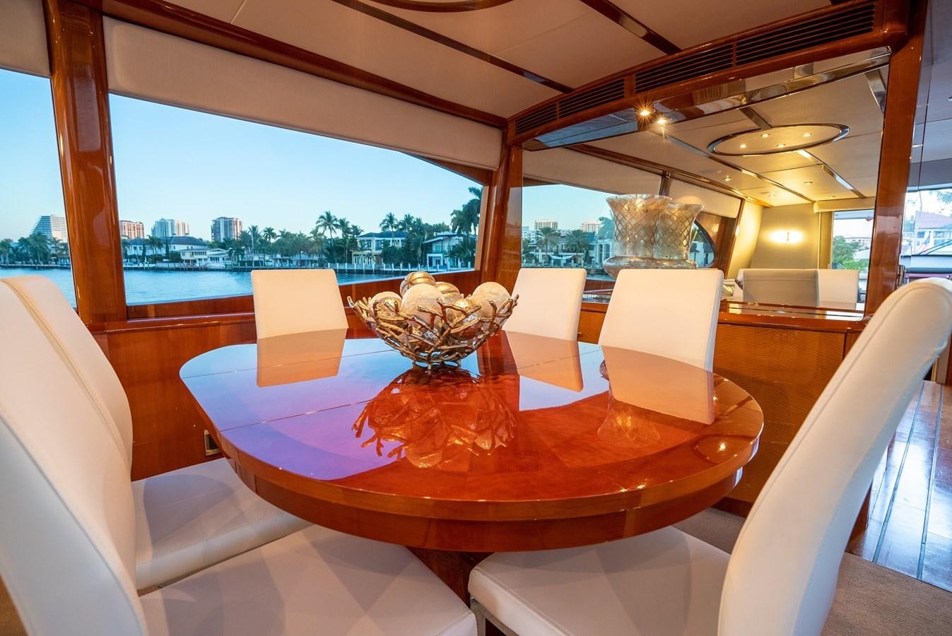 a table with chairs and a glass vase on it aboard COMPROMISE Yacht for Sale