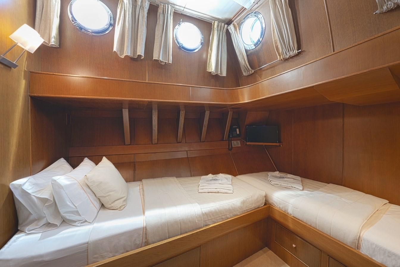 a room with beds and a television aboard ARKTOS Yacht for Sale