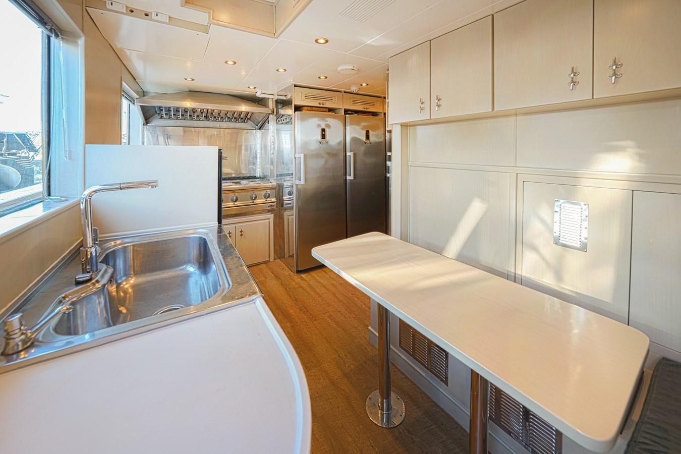 a kitchen with a countertop sink and refrigerator aboard ARKTOS Yacht for Sale
